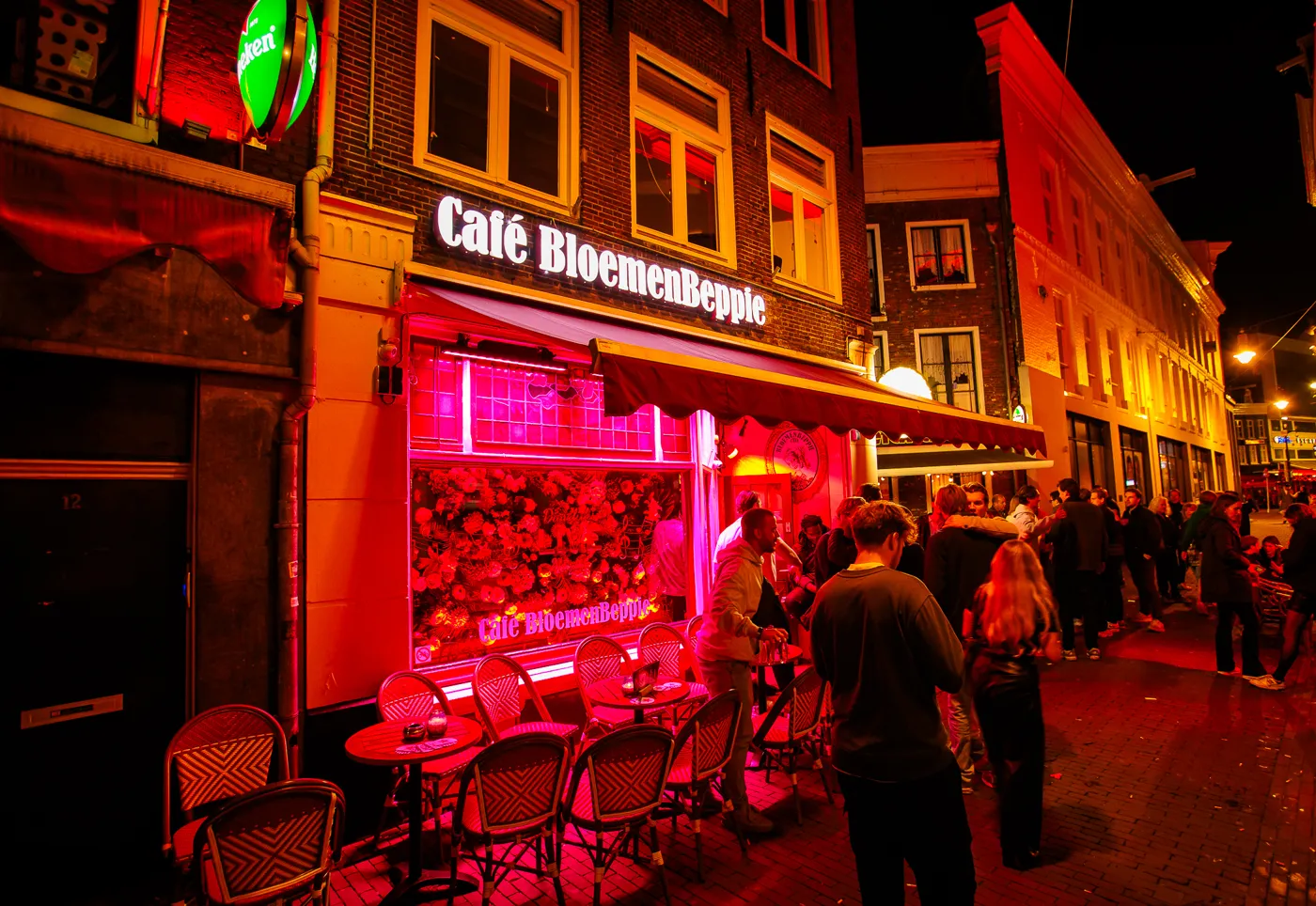 De verlichte gevel van Café BloemenBeppie in de Korte Reguliersdwarsstraat bij avond
